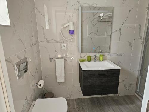 Curtido House Suits في إيهافو: حمام أبيض مع حوض ومرحاض