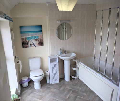 a bathroom with a sink and a toilet and a bath tub at 2 Bed Cottage Dog Child Friendly 15min walk to beach in Ederyn
