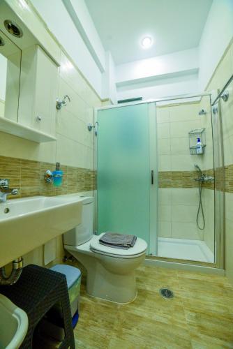 a bathroom with a shower and a toilet and a sink at Giorgos’s Luxury Apartment. in Leonidio