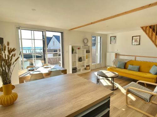 un salon avec un canapé jaune et une table dans l'établissement Ker Lina, à Locmariaquer