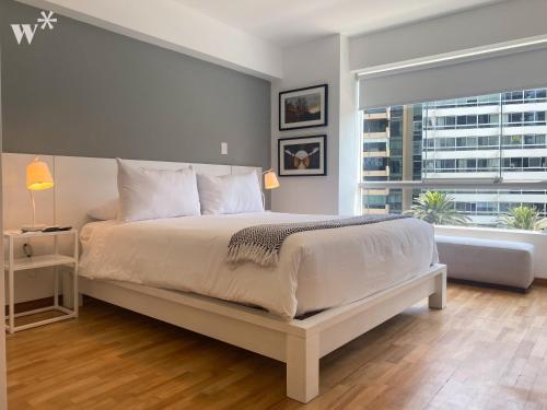 a bedroom with a large bed and a large window at Classy 2BR in Miraflores in Lima
