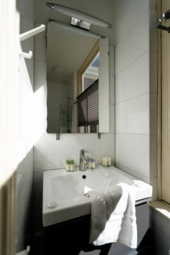 a bathroom with a white sink and a mirror at Plantage Hortus Apartments in Amsterdam