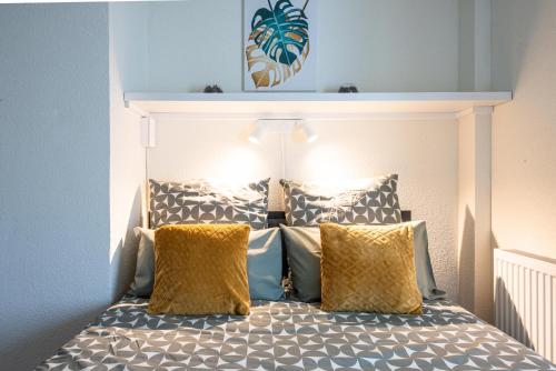 a bedroom with a bed with two yellow pillows at Mulhouse by Hardt in Mulhouse