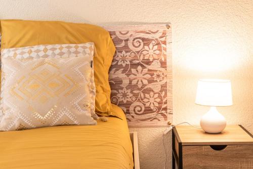a bed with a pillow and a lamp on a table at Mulhouse by Hardt in Mulhouse