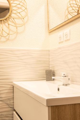 a bathroom with a white sink and a mirror at Mulhouse by Hardt in Mulhouse
