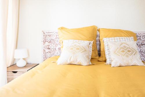 a bed with yellow sheets and white pillows at Mulhouse by Hardt in Mulhouse