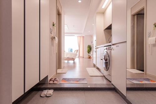 un corridoio con lavatrice e asciugatrice in una casa di The castle ocean suite a Yeosu