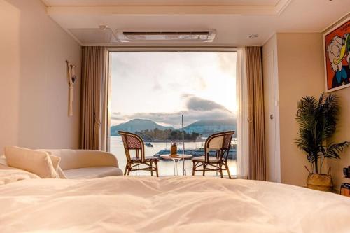 a bedroom with a bed and a table and chairs at The castle ocean suite in Yeosu