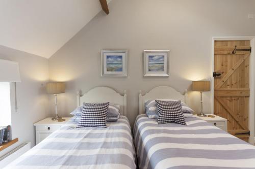 two beds sitting next to each other in a bedroom at Rose Cottage in Burnham Thorpe