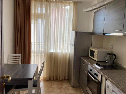 ネセバルにあるАпартаменти за семеен комфортен отдих в Равдаの小さなキッチン(テーブル、電子レンジ付)