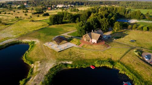 eine Luftansicht eines Hauses auf einer Insel in einem See in der Unterkunft Svencelė Resort in Svenele