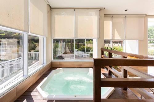 een hot tub in een kamer met ramen bij Rio Stay in Rio de Janeiro