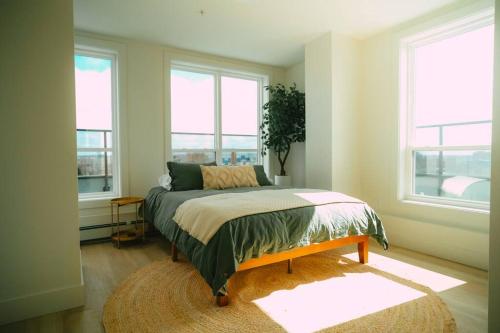 a bedroom with a bed in a room with windows at *NEW* Stylish 2BR Condo with Views in North End in Halifax