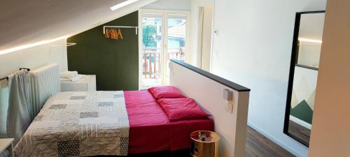 a small bedroom with a bed with a red blanket at Casa Pitem in Nago-Torbole