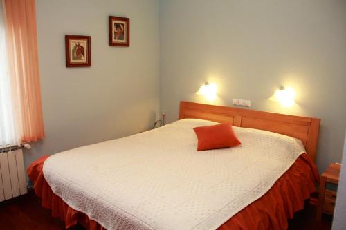 Schlafzimmer mit einem Bett mit orangefarbenem Kissen in der Unterkunft Vila Krivec in Bled
