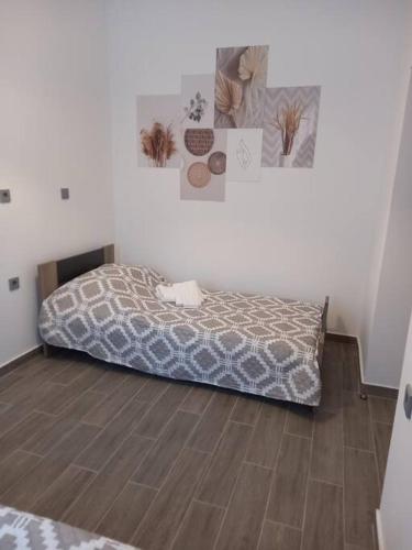 a bedroom with a bed and a wooden floor at Dipotamata House SynetI in Andros