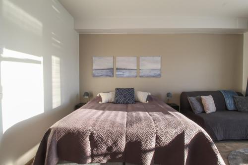 a bedroom with a bed and a couch at Pramea Apartments Aapelintupa in Kuopio
