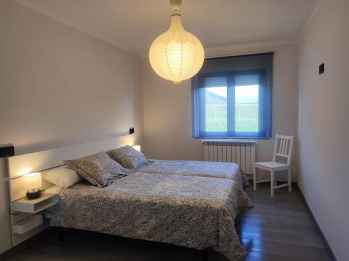 a bedroom with a bed and a lamp and a chair at El Mirador del Sella in Arriondas