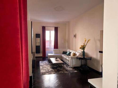 Piazza Maggiore Luxury Apartment في بولونيا: غرفة معيشة مع أريكة بيضاء وطاولة