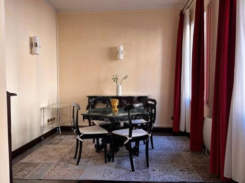 ein Esszimmer mit einem schwarzen Tisch und Stühlen in der Unterkunft Piazza Maggiore Luxury Apartment in Bologna