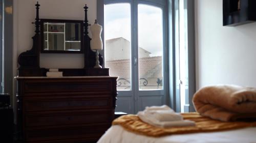 a bedroom with a bed with a dresser and a mirror at Casa Borges in Coimbra