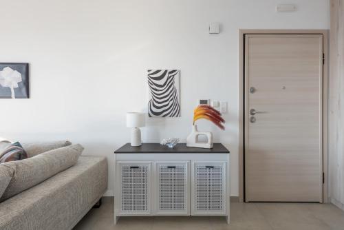 a living room with a couch and a table with a lamp at Aquarama Pool Apartments in Ixia