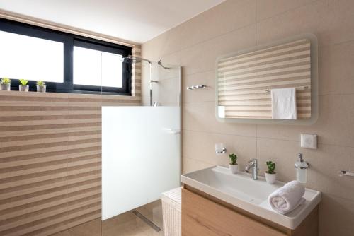 a bathroom with a sink and a mirror at Aquarama Pool Apartments in Ixia