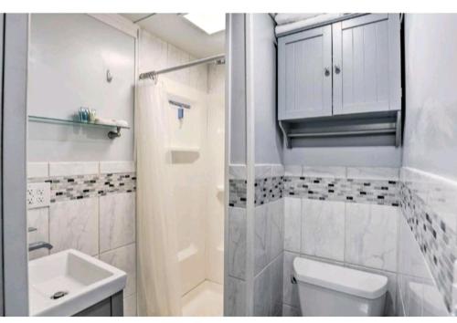 a white bathroom with a toilet and a sink at Little peace of heaven in Corning