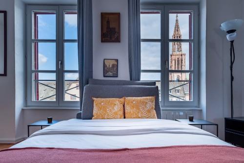 1 dormitorio con 1 cama grande y vistas a la torre en Le Batelier - Golden Tree - Centre historique - WIFI en Estrasburgo