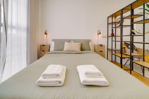 a bedroom with a large bed with two towels on it at Exquisito estudio en el Centro de Málaga in Málaga