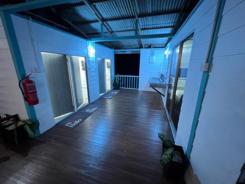 an empty room with a wooden floor and blue walls at Dormitory Pondok in Tioman Island