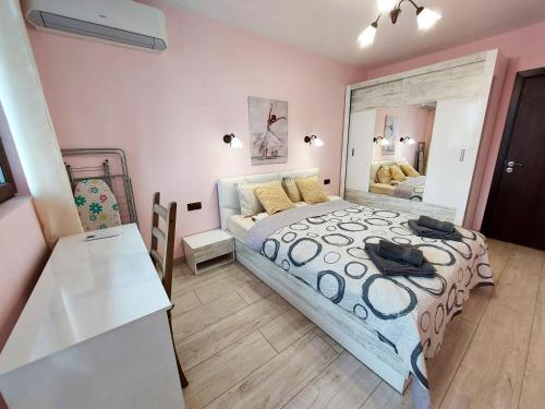 a bedroom with a large bed and a mirror at Апартаменти за гости Делукс in Burgas City