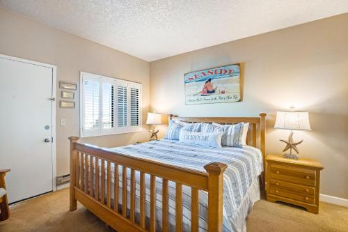 a bedroom with a wooden bed and a window at Sand & Sea: Coastal Cove (518) in Seaside