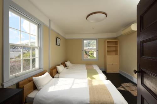 - 2 lits dans une chambre avec 2 fenêtres dans l'établissement Waterhouse Memorial - Vacation STAY 14310, à Ōmihachiman