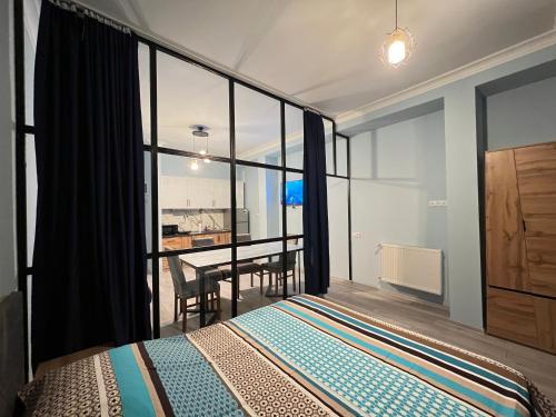 Apartment Merabi في باتومي: غرفة نوم بسرير وطاولة مع كراسي