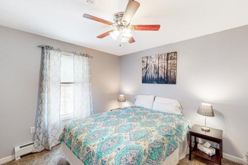 1 dormitorio con 1 cama y ventilador de techo en Cherry Valley Retreat, en Gilford