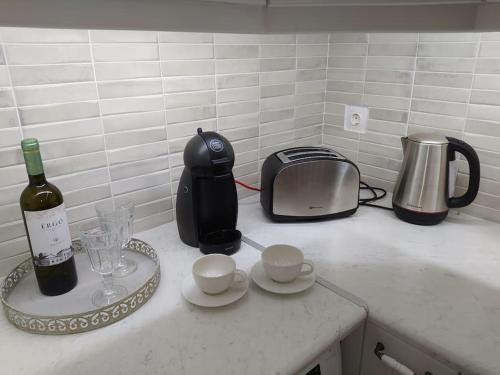 a kitchen counter with a bottle of wine and a toaster at Hydra's Harbor House in Hydra