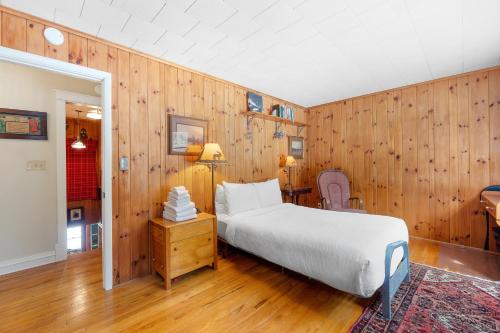 1 dormitorio con 1 cama y pared de madera en Riverside Bliss, en Chestertown