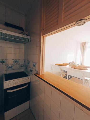 a small kitchen with a stove and a table at Piso primera línea en frente al mar in Santa Ponsa