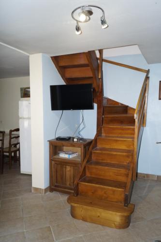 a living room with a staircase with a flat screen tv at Gîte-La Combelle in Dornas