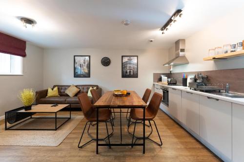 cocina y sala de estar con mesa y sofá en High Street Town House en Mánchester