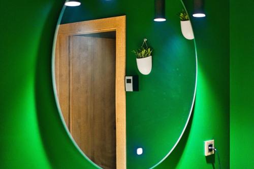a mirror in a green room with a green wall at Room4stars in Otruševec
