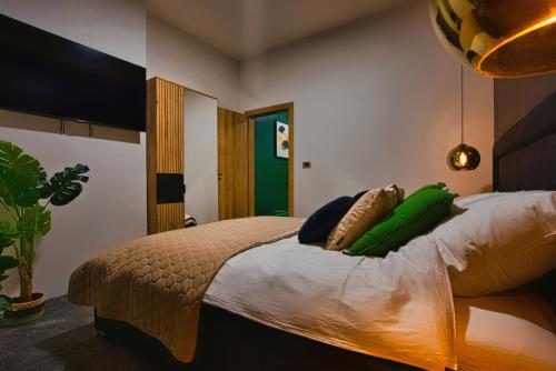 Un dormitorio con una cama con almohadas verdes. en Room4stars en Otruševec