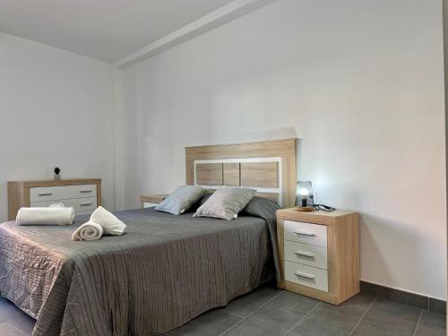 um quarto com uma cama e uma cómoda com toalhas em El Rincón - Somhome em Peníscola