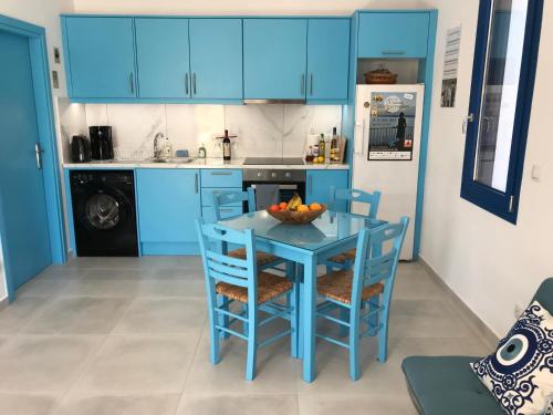 a blue kitchen with a blue table and chairs at UTOPIA RESIDENCES Kazantzakis House in Petrokefálion