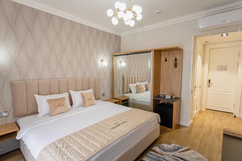 a bedroom with a large white bed with a chandelier at WELLFORT HOTEL in Samarkand