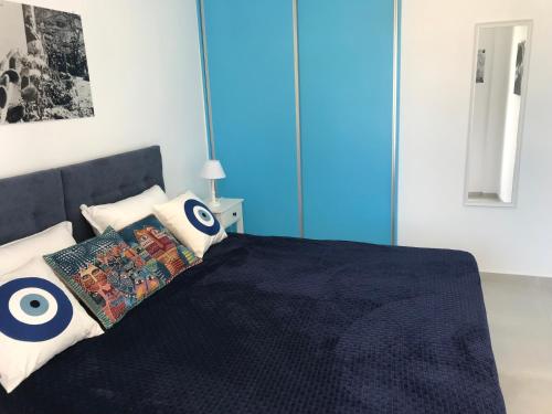 una camera da letto con un letto con una coperta nera e cuscini di UTOPIA RESIDENCES Kazantzakis House a Petrokefálion