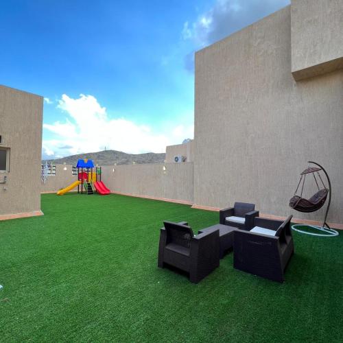 a living room with green grass and a playground at سيتي قولد للشقق الفندقيه in Taif