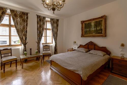 ein Schlafzimmer mit einem Bett, Stühlen und einem Kronleuchter in der Unterkunft Illo Tempore - Ultracentral Apartment in Sighişoara