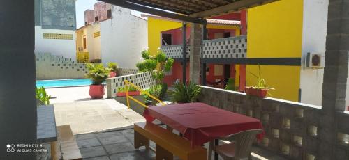 a balcony of a house with a table and a pool at Casa FORTE 3qts 200m praia ar pisc estac até 12 pessoas portaria 24H in Itamaracá